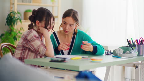 mother supports her daughter in doing her homework for school