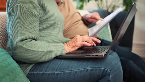 manos, una pareja de ancianos y una computadora portátil con facturas en casa