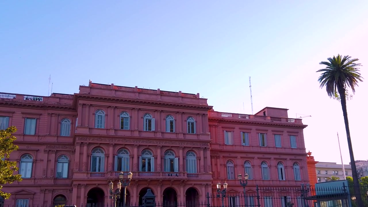 Casa Rosada, edifício nacional argentino, e palmeiras, vista lateral do horizonte ao pôr do sol.