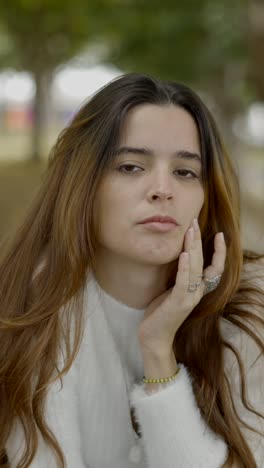 young woman with closed eyes and hand on face