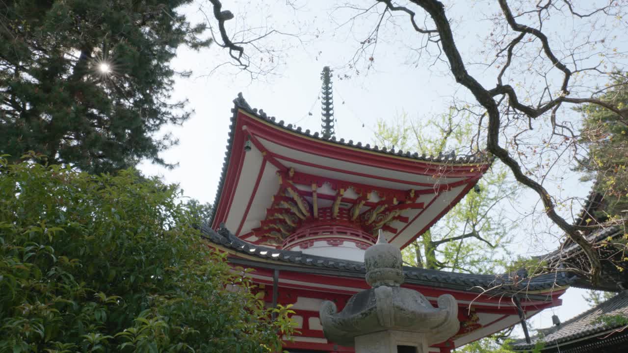 Red and white pagoda in between trees at Chionin Temple, Kyoto, Japan