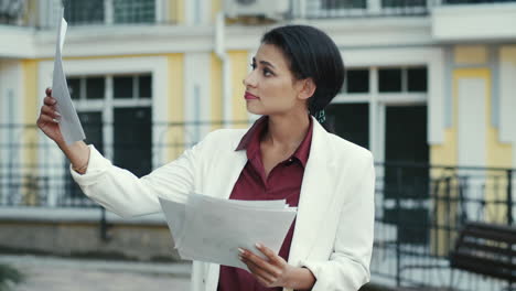 mujer de negocios examinando documentos en una calle urbana