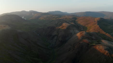 Control-Deslizante-De-Vista-De-Drones-Sobre-Un-Paisaje-Espectacular-En-Islandia.-Vista-Aérea-A-Vista-De-Pájaro-De-Las-Tierras-Altas-Cubiertas-De-Musgo-Con-Fumarolas-Humeantes-En-El-Fondo