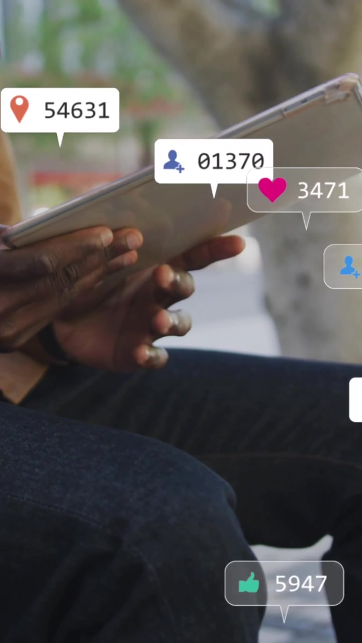 Animation of social media icons over mid section of man using tablet sitting on bench on the street