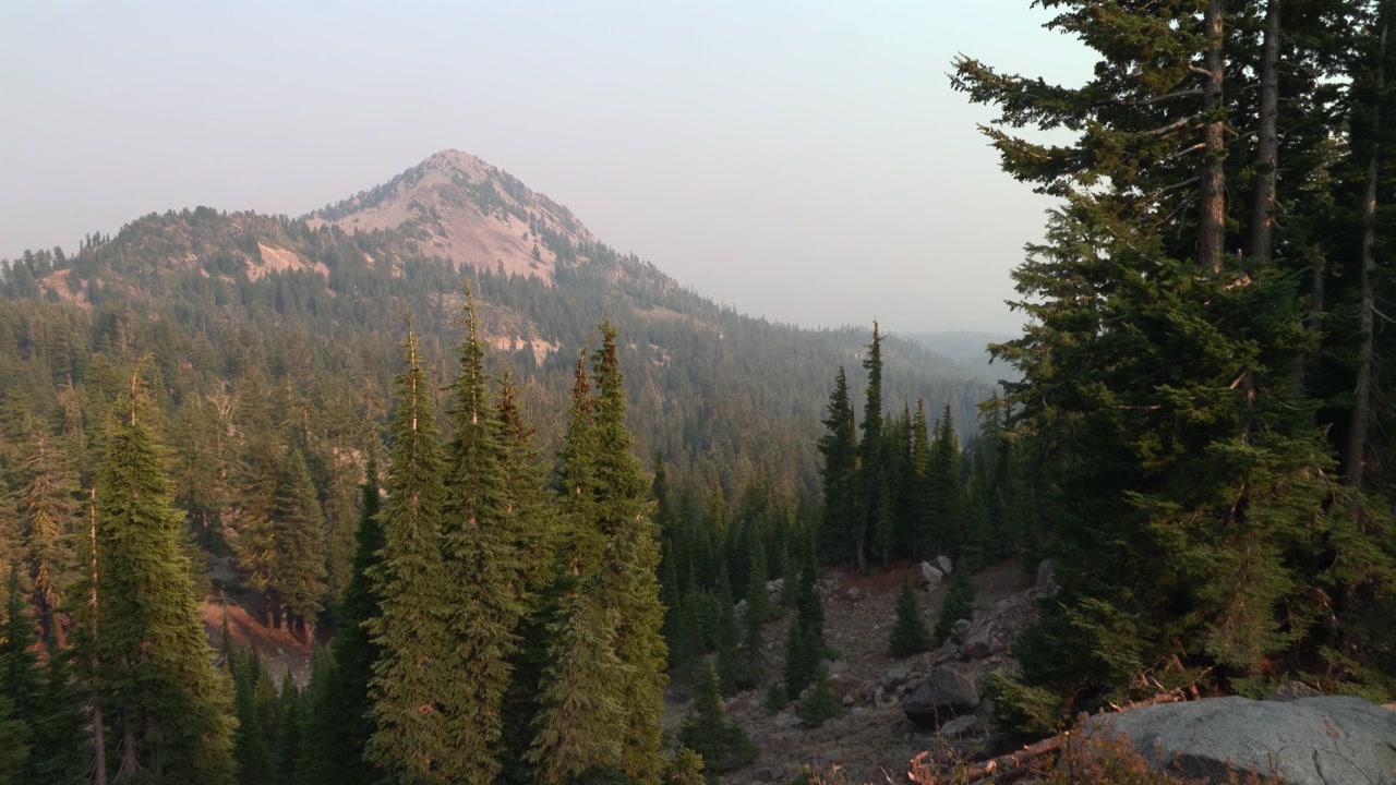 Il Reading Peak che si erge sopra una fitta foresta di conifere nel Parco Nazionale Vulcanico di Lassen, California settentrionale, USA. Paesaggio montano vulcanico aspro, inquadratura fissa di presentazione.