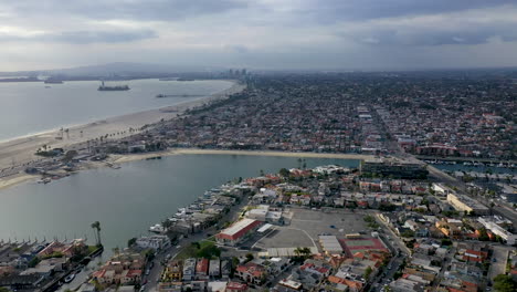 long beach california, usa. beautiful aerial panning shot of houses, trees, blue water and beach. establishing shot of the area