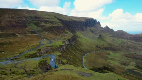 road up to quiraing, isle of skye, scotland. - aerial view on cloudy day with blue skies