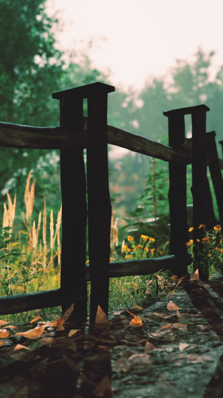 valla de madera en un jardín de otoño con niebla