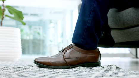 man lacing up brown dress shoes