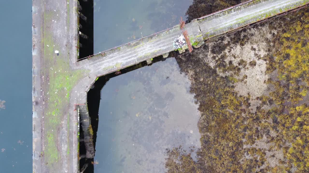viejo embarcadero cerca del edificio abandonado de la gama de torpedos en loch long cerca de arrochar, tierras altas escocesas, costa oeste de escocia - material de archivo hd de drones aéreos 4k, de arriba hacia abajo