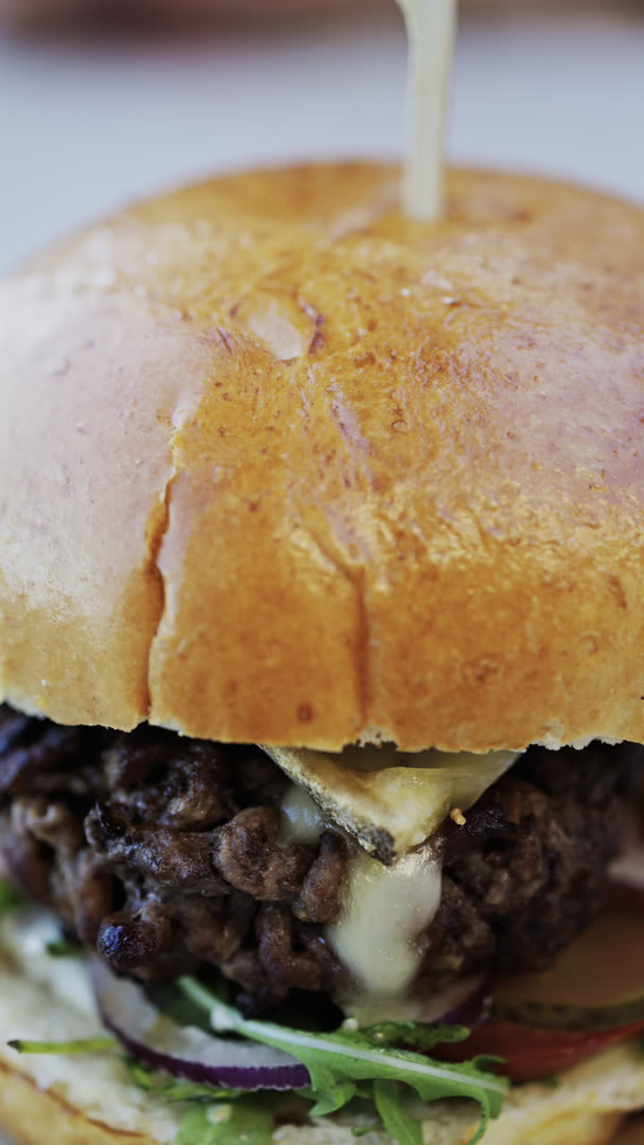 Close up of a hamburger on a plate at a restaurant. Vertical