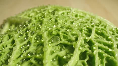 wet green salad leaves on wooden table, macro close up probe lens