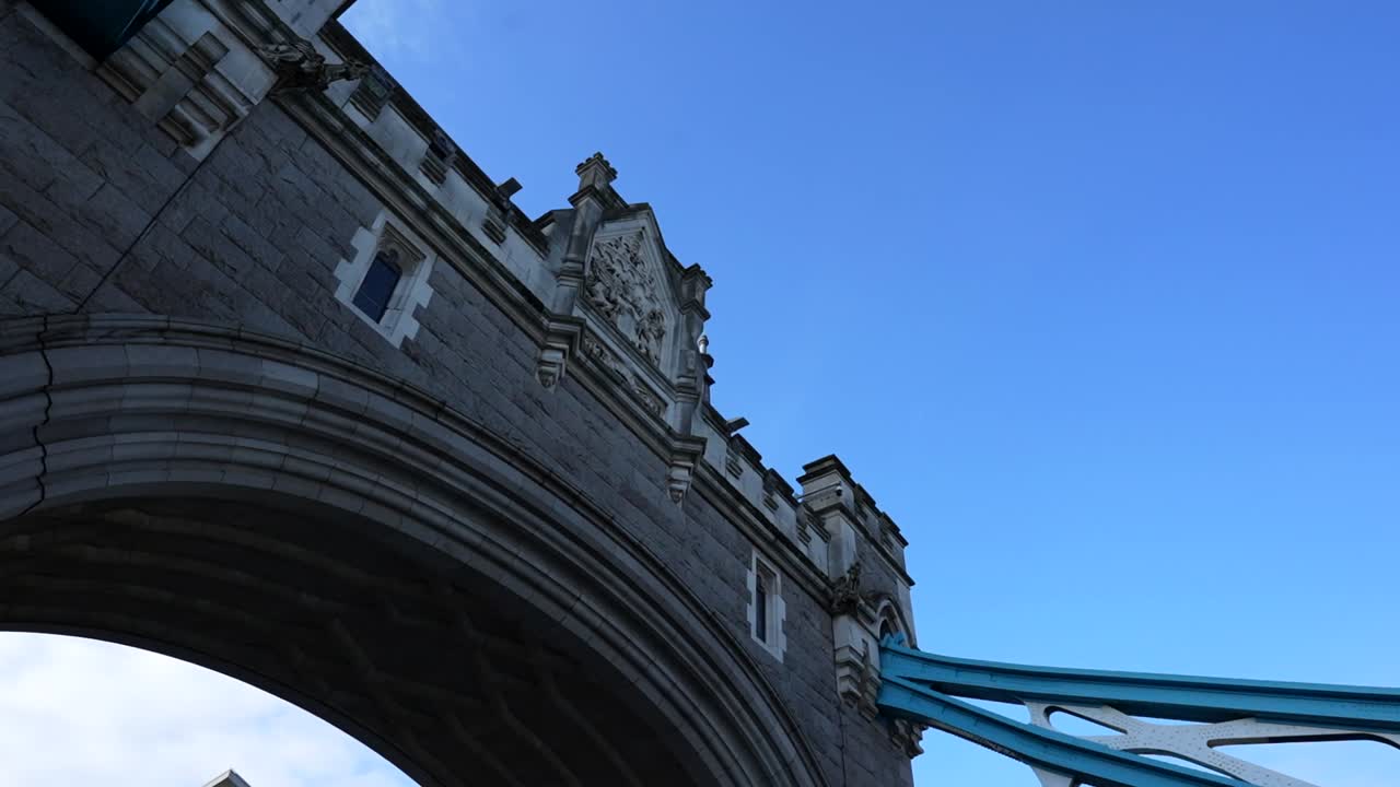 Low angle view of Tower Bridge in London under a clear blue sky as a bird flies past