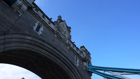 low angle view of tower bridge in london under a clear blue sky as a bird flies past