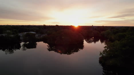 drone flies over the lakes in roger williams park during a beautiful orange sunset