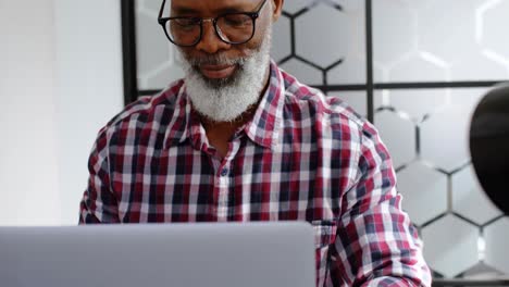 Senior male executive using laptop at desk 4k