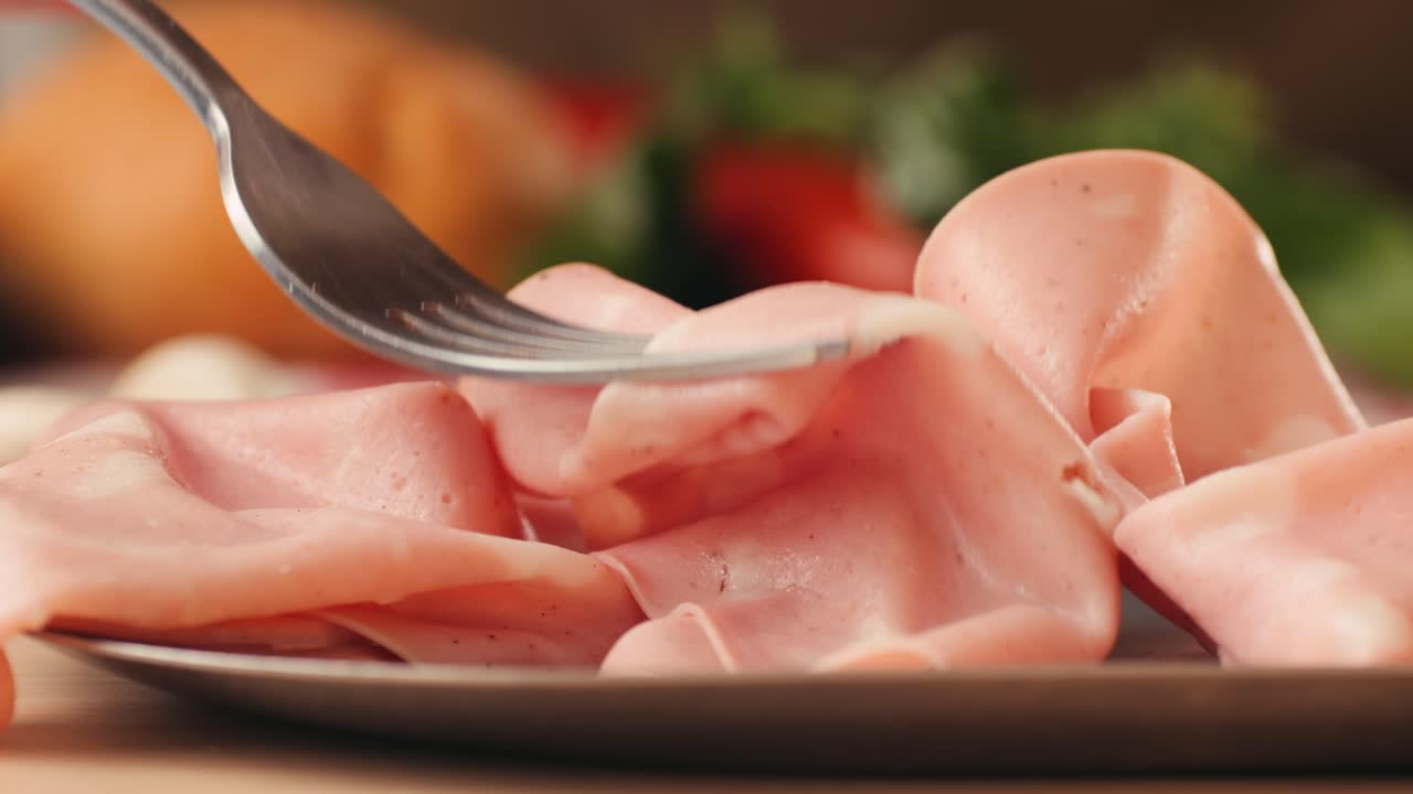 Ham italian mordatella, man Slices Of Traditional Italian antipasti mortadella sausage on a wooden cutting board, close up macro of chicken or turkey jamon, fat breakfast dish.