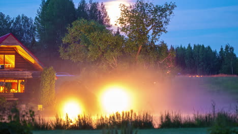 low-lying misty fog makes the nighttime lights at a cabin glow - time lapse