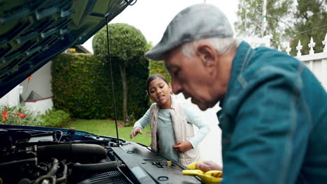 grandfather teaching granddaughter about car engine maintenance