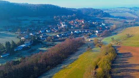 early morning aerial view of a quaint village nestled in hills