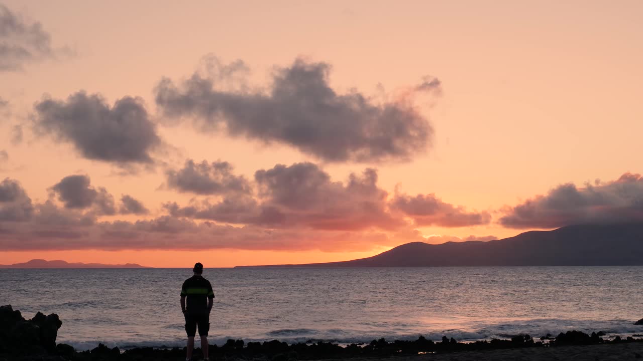 해변에서 해가 지는 것을 보는 남자