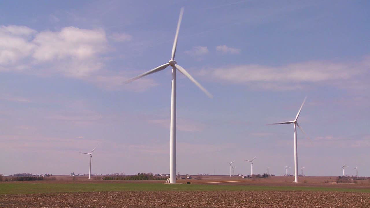 Giant windmills in the distance generate power behind farms in the American midwest 5