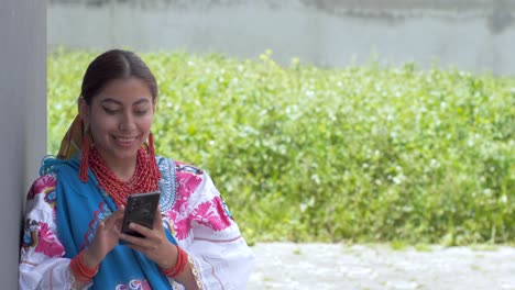 Clip-Cinematográfico-De-Una-Joven-Latina-Morena-Vestida-Con-El-Traje-Tradicional-Llamado-Cayambeñas-Usando-Su-Teléfono-Y-Tomándose-Una-Foto-Selfie