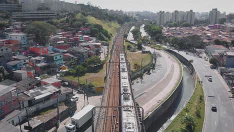 imagen de paisaje aéreo - volando sobre el tren subterráneo de tugurios en el distrito de capão redondo, ciudad de são paulo en brasil