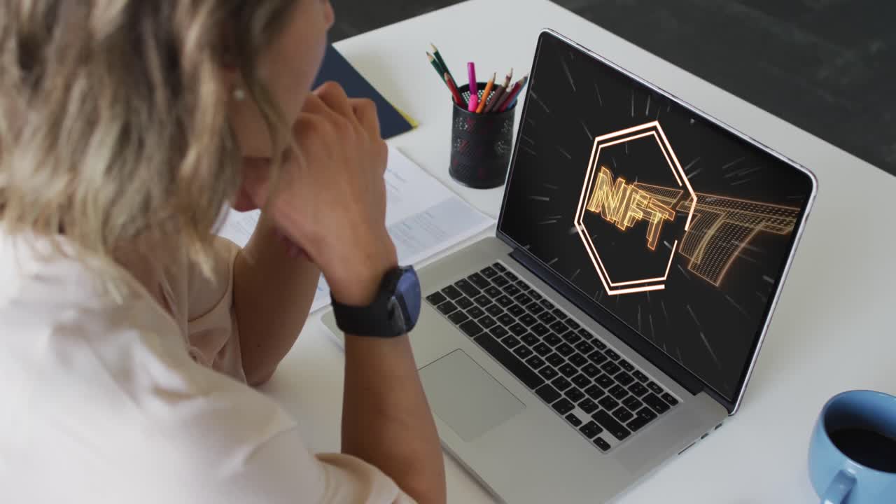 video de una mujer caucásica trabajando en una computadora portátil con nft en la pantalla