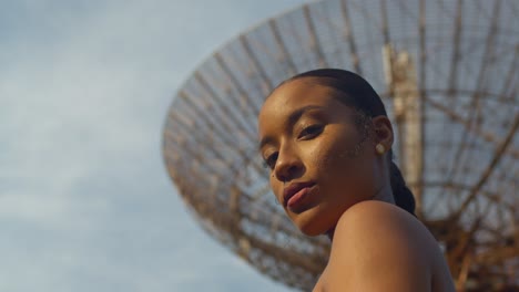 Extreme-close-up-of-a-model-standing-in-front-a-military-radar-tracking-station