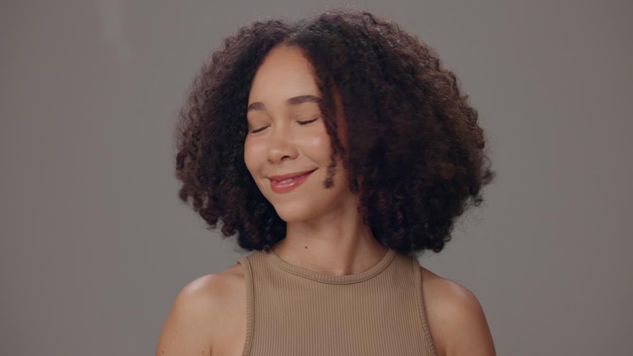 una mujer joven con el cabello rizado riendo