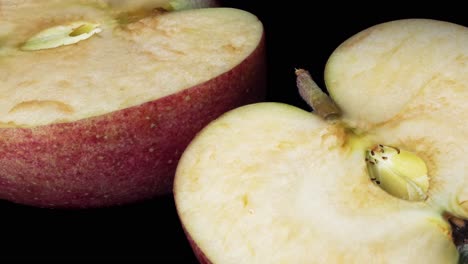 Macro-time-lapse-shot-of-rotting-apple-lying-on-black-surface-in-studio