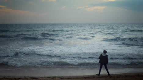 solitude in motion - teenage boy dancing at dusk on the ocean beach