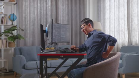 programador que experimenta dolor de espalda mientras trabaja
