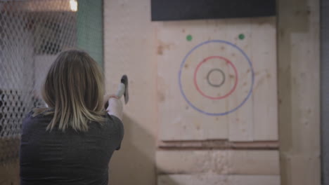 Woman Throwing Axe at Target in Indoor Axe Throwing Range