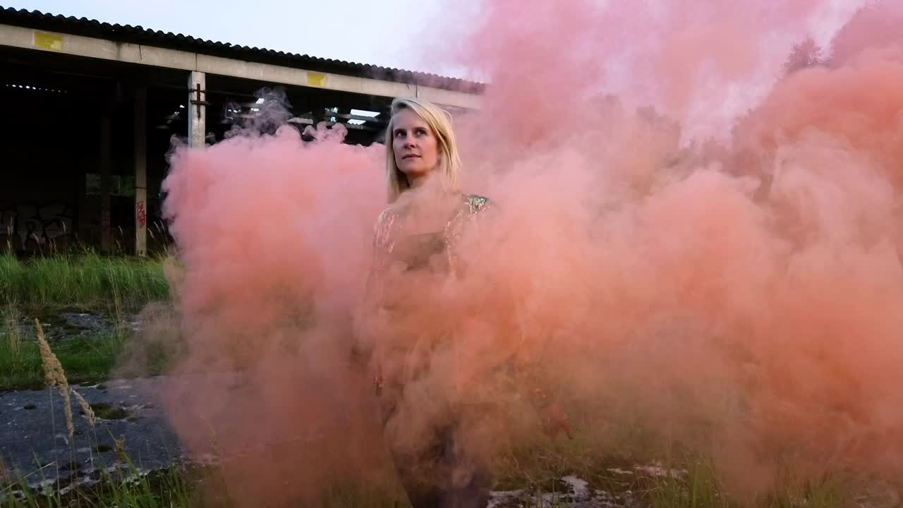 Unbelievable slow motion cinematic shot of Girl runs through an orange cloud of toxic fog.Colorful fog shooting. Gimbal foto video shoot on lost places in wild nature 1080, 24p by Philipp Marnitz