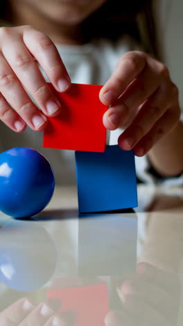 child's hands playing with colorful building blocks
