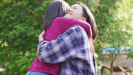 Video-of-happy-asian-mother-and-daughter-embracing-and-having-fun-in-garden