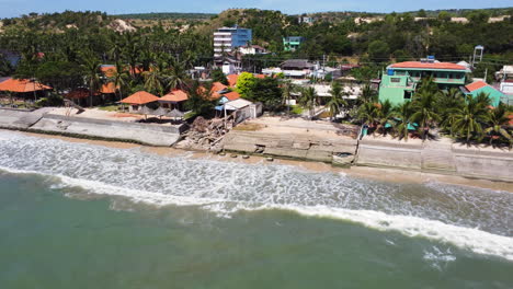 Coastline-in-Mui-Ne,-Vietnam,-different-ways-of-coast-protection-from-erosion,-concrete-wall-and-geotubes,-aerial