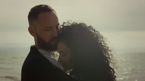 young people cuddling outdoors. married couple embracing at sea beach shore.