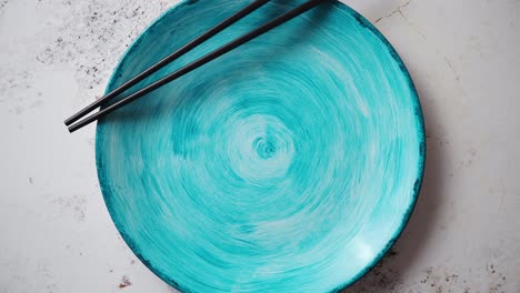 Turquoise-hand-painted-ceramic-serving-plate-with-wooden-chopsticks-on-side