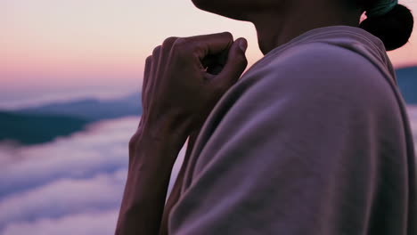 woman meditating on a mountaintop at sunrise