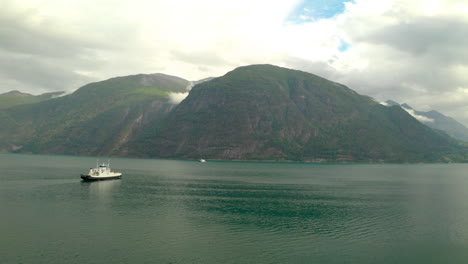 Barco-Navegando-En-El-Fiordo-De-Geiranger-Con-Vistas-A-La-Montaña-En-Sunnmore,-More-Og-Romsdal,-Noruega