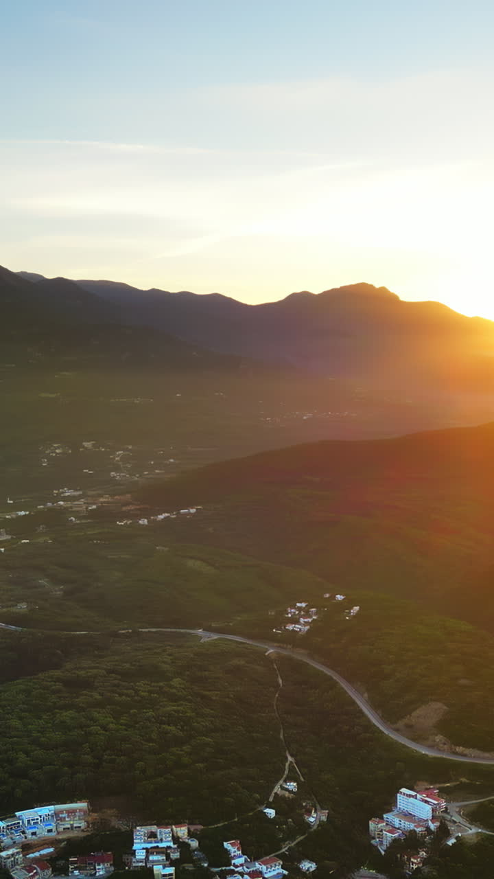 Aerial, drone view of buildings on the shore of the Adriatic sea, with mountains on the background in Montenegro. Vertical
