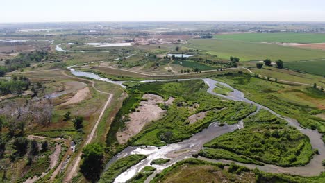 Vídeo-Aéreo-De-Drones-Que-Muestra-Canales-Fluviales-En-Un-Sereno-Paisaje-Rural,-Con-Amplios-Pastizales-En-El-Horizonte