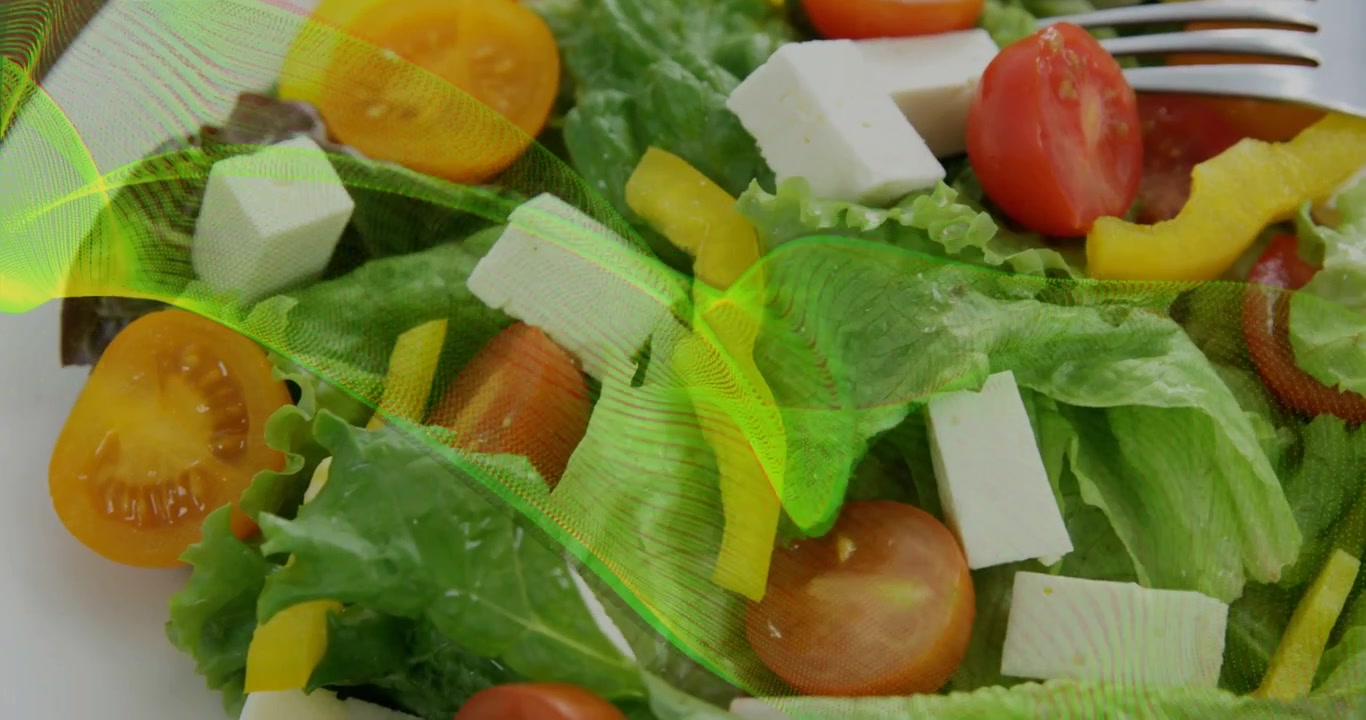 Cinta verde neón apareciendo sobre un plato blanco recorriendo la ensalada mientras la cámara hace zoom, mostrando frescura.