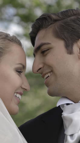 groom kissing his pretty new wife in a park