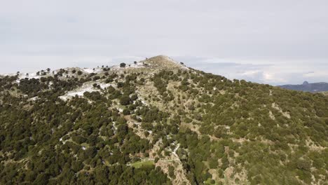 Paisaje-De-Cerdeña-En-Invierno,-Cima-De-La-Colina-Cubierta-De-Nieve-Ligera,-Antena,-Adelante