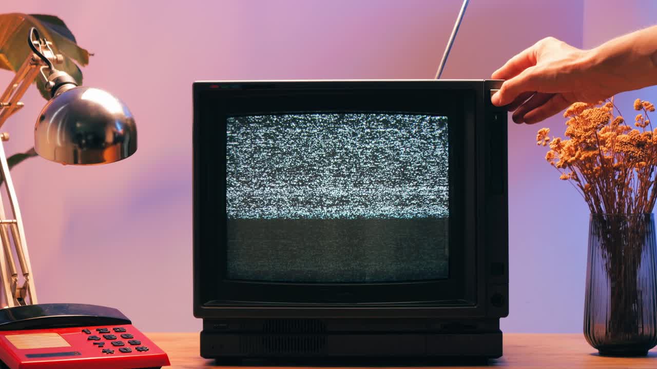 TV retrò, televisione vintage. In un'ambientazione nostalgica, un televisore retrò mostra grana sullo schermo, dispositivo per una spaventosa notte di Halloween, ottimo per chroma key e green screen. Filmato 4K di alta qualità.