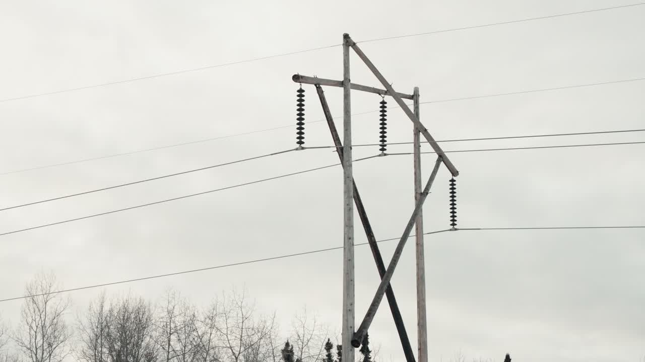 Slow Close Up Overcast Panning Shot Large Wooden Electricity Network Phone Transmission Tower Electrical Pylon Carrying High Voltage Current Long Distances Outdoor Environment Power Infrastructure